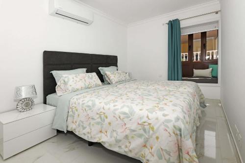 ein weißes Schlafzimmer mit einem großen Bett und einem Fenster in der Unterkunft Casa Gerald in Costa Del Silencio