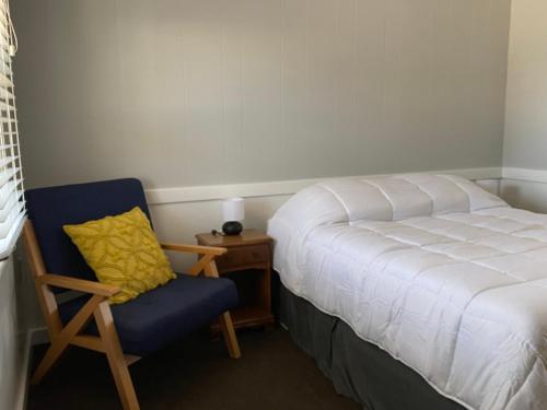 a bedroom with a bed and a chair and a desk at Tower Circle Motel in Buxton