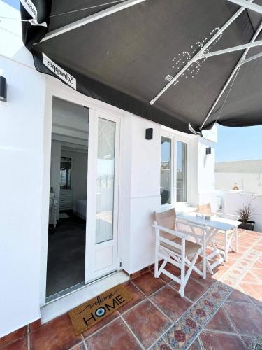 a table and chairs on a patio with a black awning at Deluxe Ιδιωτικό δωμάτιο στην πόλη της Νάξου in Naxos Chora