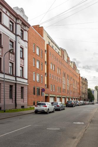 a street with cars parked in front of buildings at Jekabpils 2 Apartment in Rīga