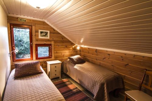 a bedroom with two beds in a log cabin at Lomakulkuri Apartments in Vuokatti