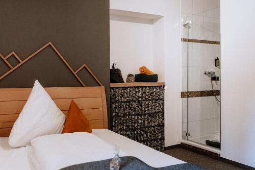 a bedroom with a bed and a shower at Das Schutzhaus-Bed and Breakfast-Dein Basislager im Salzkammergut in Bad Aussee