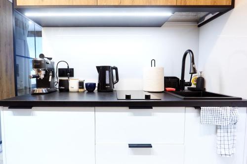 a kitchen with a black counter top with appliances at Apartament "Powoli" z darmowym parkingiem in Karpacz