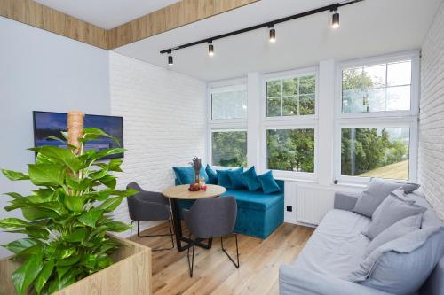 uma sala de estar com um sofá azul e uma mesa em Apartament "Powoli" z darmowym parkingiem em Karpacz