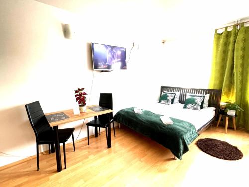a bedroom with a bed and a desk and a table at Studio przy Starówce in Olsztyn