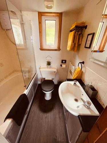 a bathroom with a sink and a toilet and a tub at The Rowanberry Suite at Rowan Cottage in Elgol