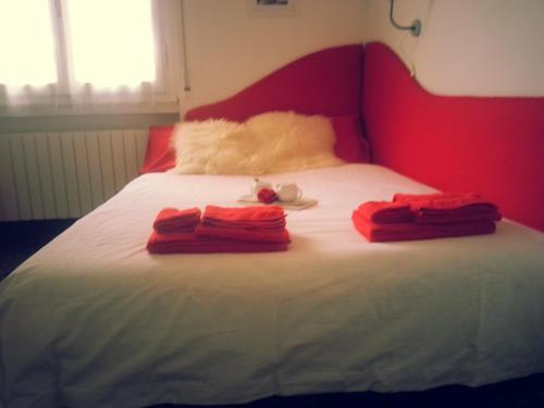ein Bett mit zwei roten Handtüchern darüber in der Unterkunft Appartamento Lily in Florenz