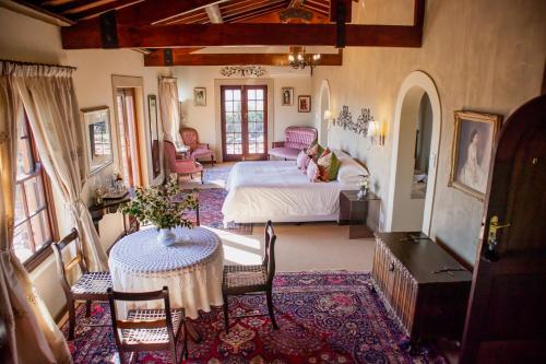 a bedroom with a bed and a table and chairs at Casa Mori House in Stellenbosch