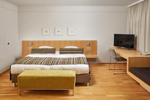 a bedroom with a bed and a desk and a television at Reykjavik Natura - Berjaya Iceland Hotels in Reykjavík