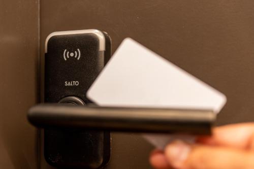 a person holding a cell phone in front of a door at The CORNR Hotel in Nieuwpoort