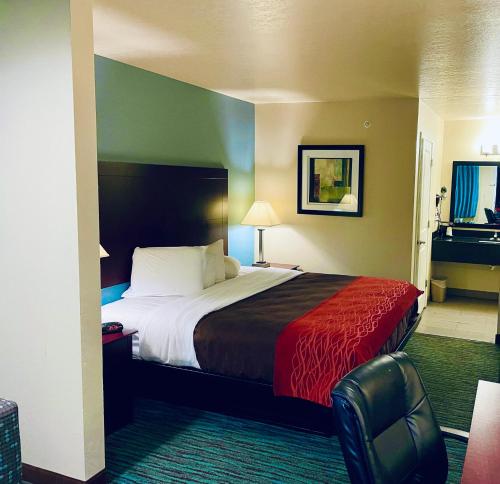 um quarto de hotel com uma cama e uma cadeira em Garden Inn and Suites em Little Rock