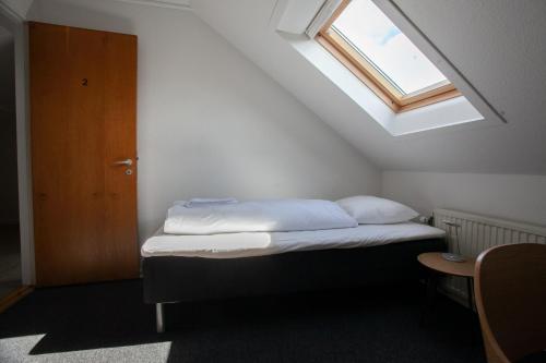 a bedroom with a bed with a window and a door at The Bird / Guesthouse / 10 min Walk Downtown in Tórshavn