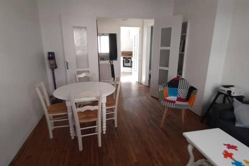 uma sala de estar com uma mesa branca e cadeiras em Ker Armand, appartement Thabor proche hyper centre em Rennes