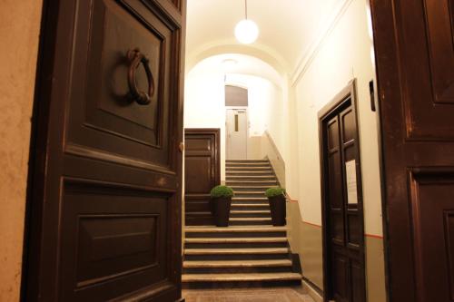 a hallway with stairs and a door with potted plants at Locanda Navona in Rome