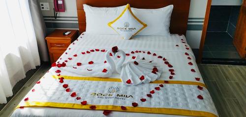 a bed in a hotel room with red hearts on it at Rockmila Hotel in Phu Quoc