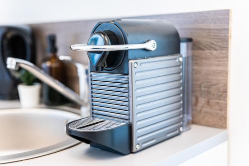 un grille-pain assis sur un comptoir à côté d'un évier dans l'établissement Appartement T2 GDX Privilège - Bourg en Bresse - Centre Ville & Gare, à Bourg-en-Bresse