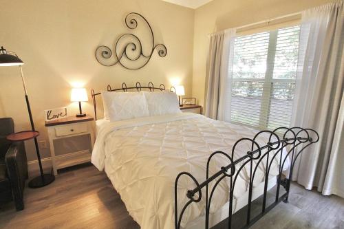 een slaapkamer met een bed met een wit dekbed en een raam bij PGA Village Golf Villas I 9808A in Carlton