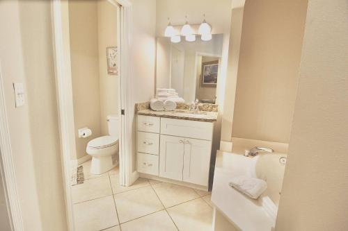 een witte badkamer met een toilet en een wastafel bij PGA Village Golf Villas I 9808A in Carlton