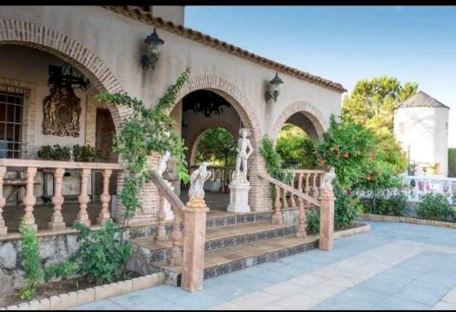 ein Haus mit einer Treppe vor einem Gebäude in der Unterkunft Villa los olivos in Miguel Esteban