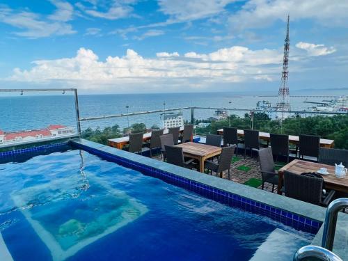 a swimming pool with a view of the ocean at Rockmila Hotel in Phú Quốc