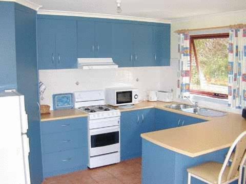 a kitchen with a stove top oven and a microwave at Cape Bridgewater Seaview Lodge in Cape Bridgewater