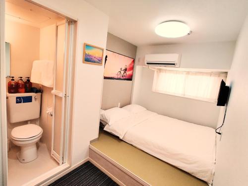 大阪市にあるda innのベッドとトイレ付きの小さな部屋です。