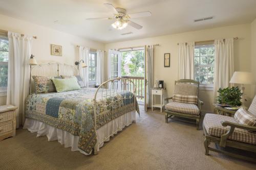 1 dormitorio con 1 cama, 1 silla y ventanas en Sunflower Hill Inn en Moab