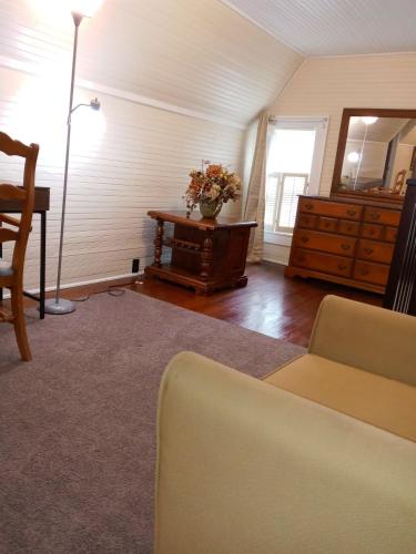 a living room with a couch and a table with a dresser at Brick House Retreat in Hamlet
