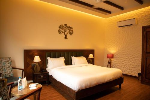 a bedroom with a bed and a table and a chair at Palm Villas in Amritsar
