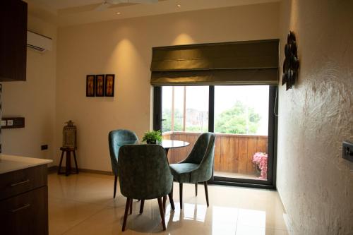 a dining room with a table and chairs and a window at Palm Villas in Amritsar