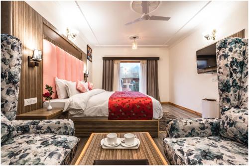 a hotel room with a bed and two chairs at Sangaylay palace in Leh