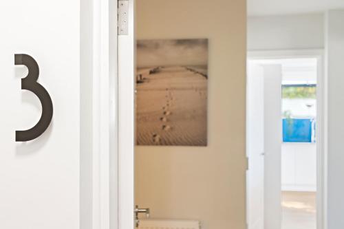 a door with a picture hanging on the wall at Stunning Coastal Apartment in Maidencombe with Sea Views & Garden in Stokeinteignhead