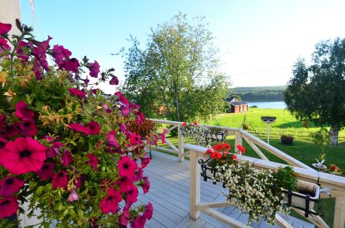 a wooden deck with flowers and benches on it at Villa Sisu in Överkalix