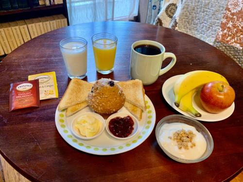 una mesa con una bandeja de alimentos y bebidas para el desayuno en Garden District Bed and Breakfast, en Nueva Orleans