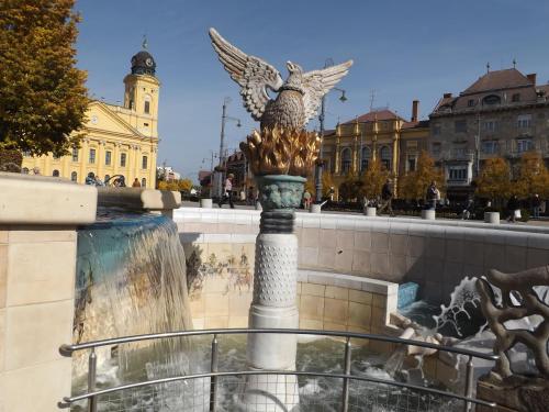 a statue of an angel on a fountain in a city at Visit Debrecen Apartman in Debrecen