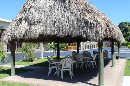 a table and chairs under a straw umbrella at Quality Inn Florida City - Gateway to the Keys in Florida City