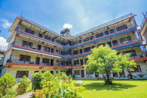 a large building with a tree in front of it at Butterfly Lodge in Pokhara