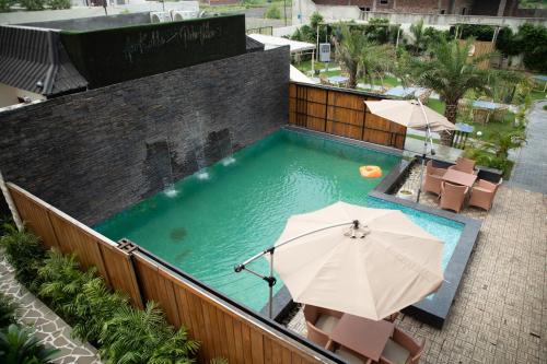 an overhead view of a pool with umbrellas and chairs at Palm Villas in Amritsar
