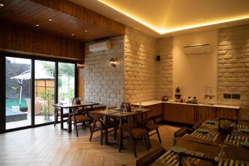 a restaurant with tables and chairs in a room at Palm Villas in Amritsar