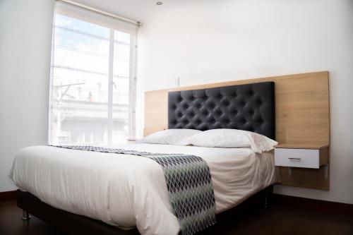 una camera da letto con un grande letto con una grande finestra di HotelSuizaApartamentos a Ipiales