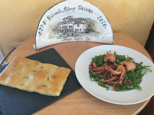 a plate of food on a table with a plate of food at Albergo Ristorante Turchino in Campo Ligure