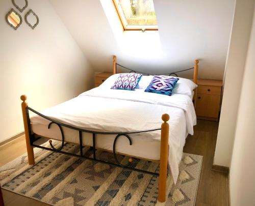 um quarto com uma cama com lençóis brancos e uma janela em Apartament Natura em Koszalin