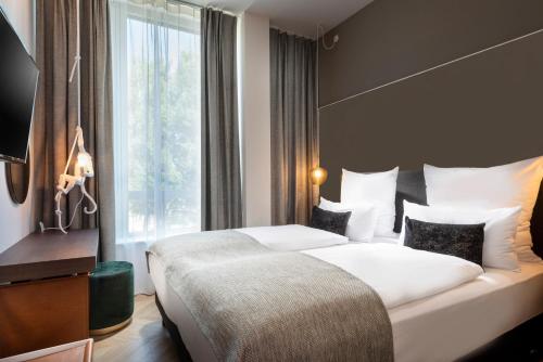 a hotel room with two beds and a window at Flightgate Munich Airport Hotel, a member of Radisson Individuals in Hallbergmoos