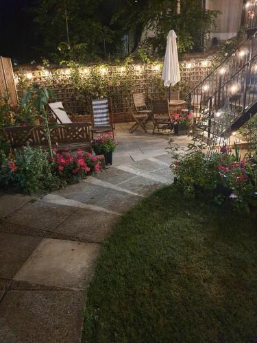 a patio with benches and flowers and lights at The Sky Penthouse in Winchester