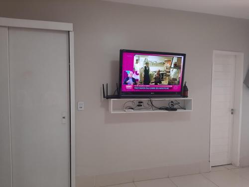 a television sitting on a shelf in a room at FlatStudio05 na Nova Betânia - INNOVA in Mossoró