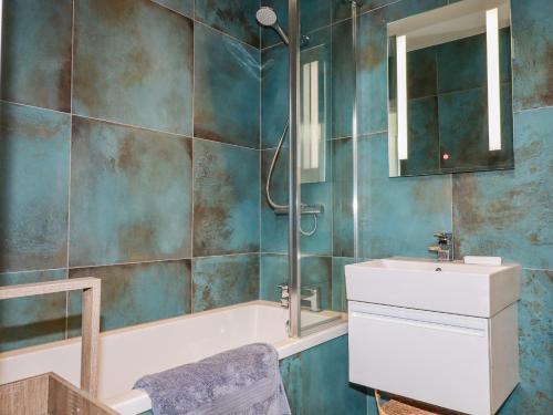 W łazience znajduje się wanna, umywalka i lustro. w obiekcie Stargazers w mieście Penzance