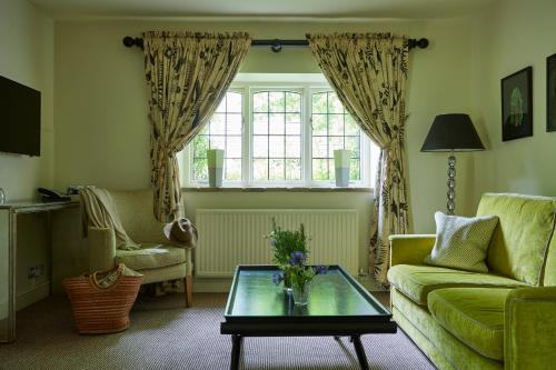 a living room with a couch and a table at The Slaughters Country Inn in Lower Slaughter