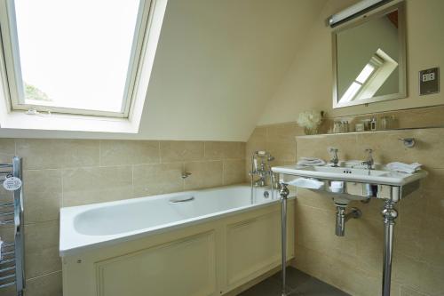 a bathroom with a sink and a mirror at The Slaughters Country Inn in Lower Slaughter