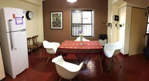 a kitchen with a table and white chairs and a refrigerator at Departamento Familiar Amplio y Luminoso en Rafaela in Rafaela
