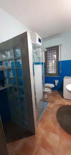 bagno con doccia in vetro e servizi igienici di Isuedda a Marrùbiu